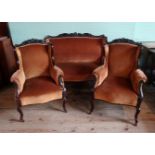 A late Victorian three piece salon suite, comprising: two seater sofa and a pair of armchairs,