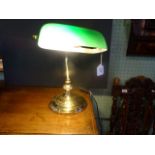 A brass desk lamp with adjustable green glass shade (32cm tall).