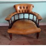 A leather upholstered curved club chair (72cm wide).