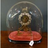 A 19th century brass skeleton clock on stand and under dome,