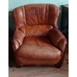 A contemporary tan leather upholstered armchair (85cm wide).