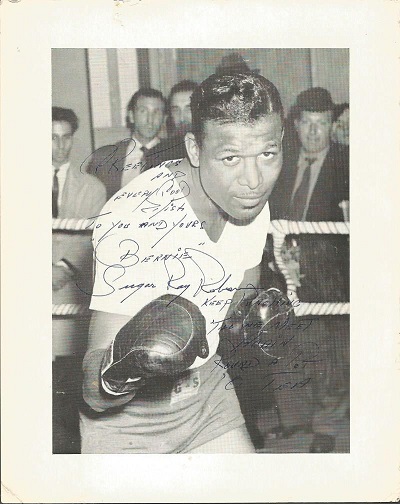 Sugar Ray Robinson 10 x 8 inch b/w photo in the training ring with gloves on. Inscribed and
