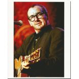 Elvis Costello signed 10 x 8 inch colour photo on stage playing the guitar. His critically acclaimed