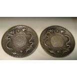 A pair of early 20th century Chinese silver coin inset dishes, 10cm (4 in) diameter (2)  Good