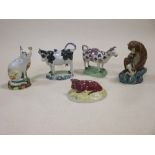 Two Staffordshire cow creamers, a seated pottery cat and a monkey etc (5)