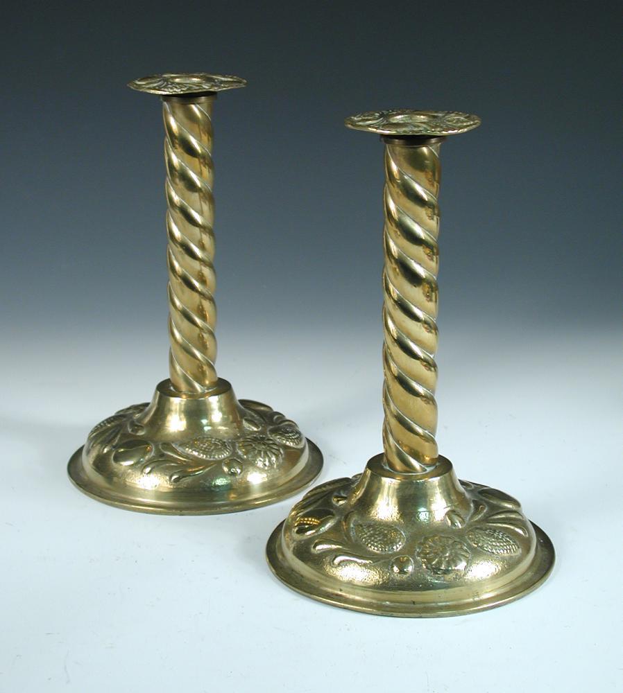 A pair of Arts & Crafts brass candlesticks, each with twist columns, the scones and spreading