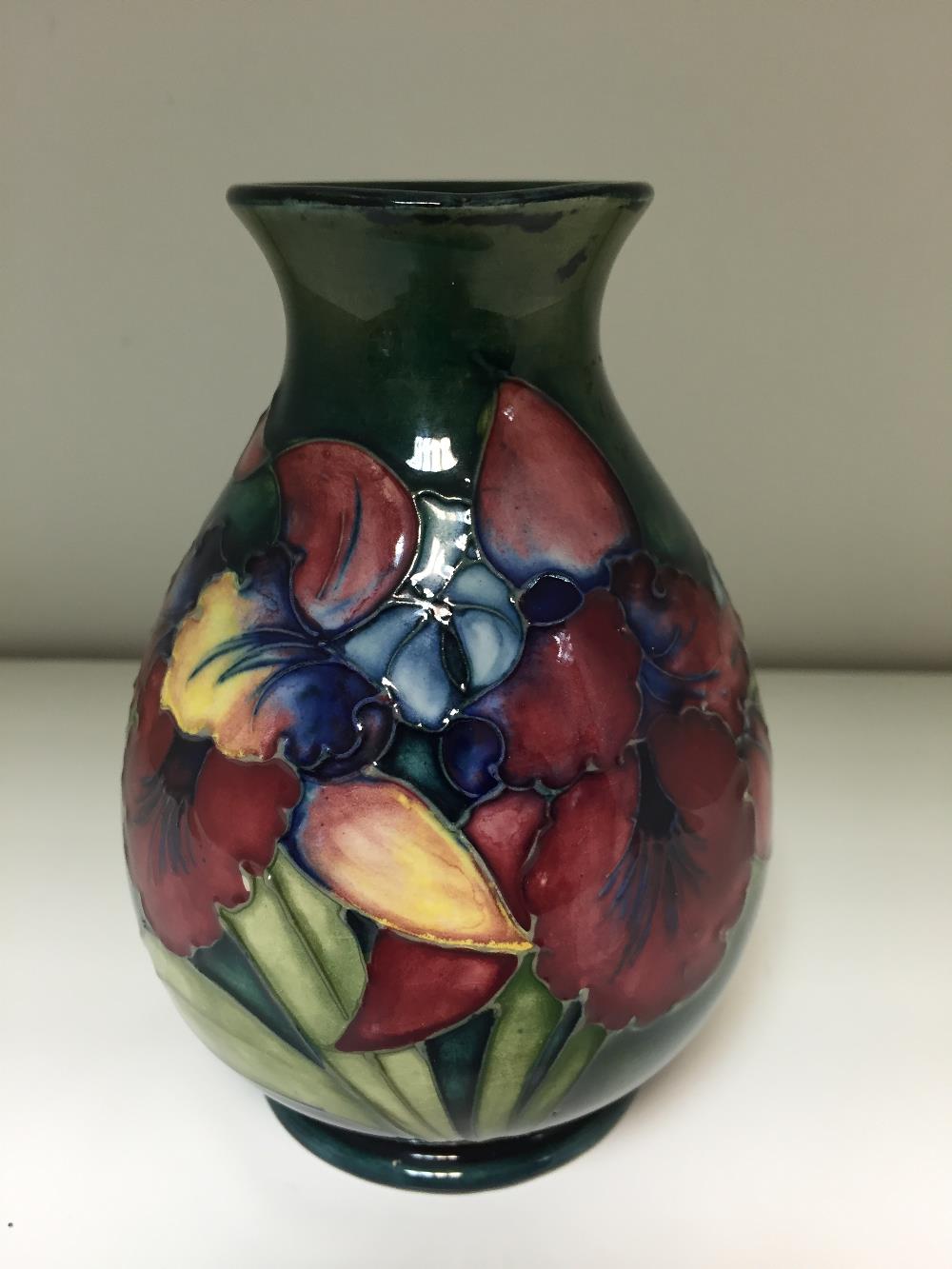 A Moorcroft Orchid pattern vase, the baluster form decorated to a green ground, impressed marks