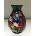 A Moorcroft Orchid pattern vase, the baluster form decorated to a green ground, impressed marks