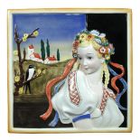 Attributed to Lenci, a porcelain plaque, decorated in relief with a maiden, a church behind and a