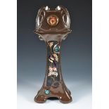 A Bretby Pottery Art Nouveau mantle clock, the front panel decorated with an orientalist finch on