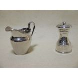 A silver pepper mill and a silver cream jug (2)