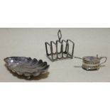 A silver scallop shaped dish, 1885, together with a toast rack and a small mustard