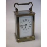An Edwardian brass carriage clock, the enamel dial with retailers name JAS SHOOLBRED & Co, Tottenham