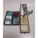 A German World War II mothers medal, a US 1971 silver dollar and a silver swimming medal