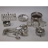 A silver toast rack, a wine coaster, napkin rings and various silver spoons etc