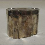 A silver tea caddy and cover