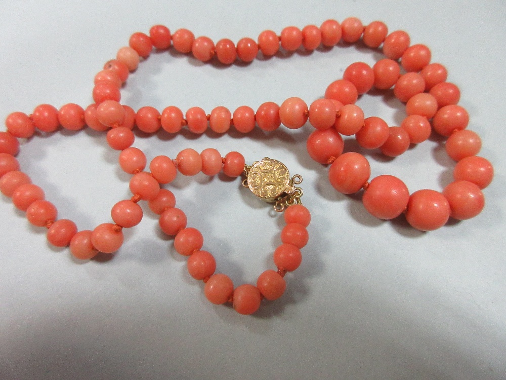 A graduated strand of coral beads and an early plastic carved 'coral' bangle, the necklace of - Image 2 of 7
