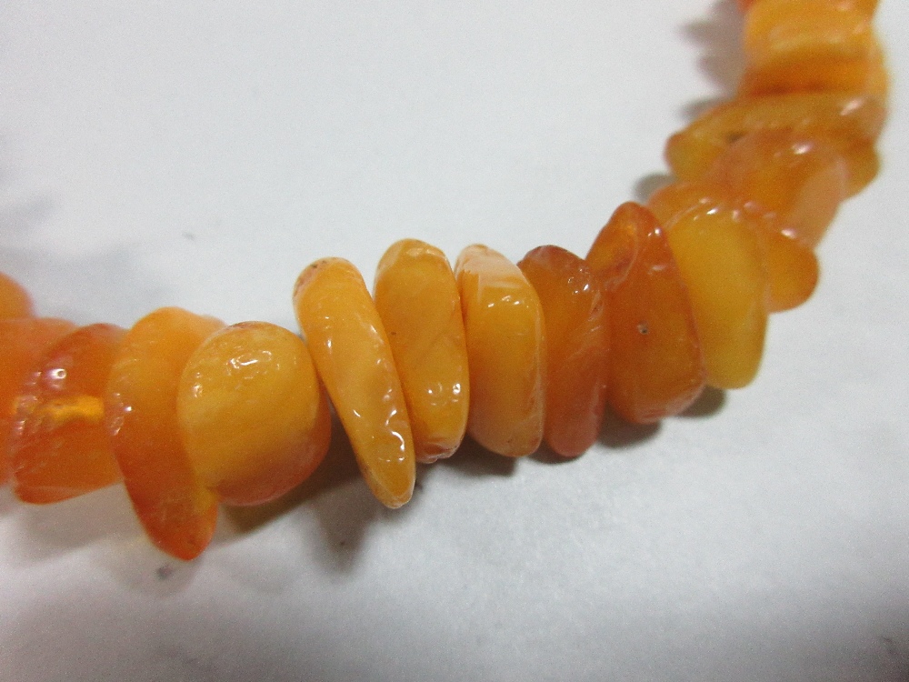 A butterscotch amber bead necklace, of graduated randomly shaped 'pebble' beads, gross weight 41.8g, - Image 2 of 4