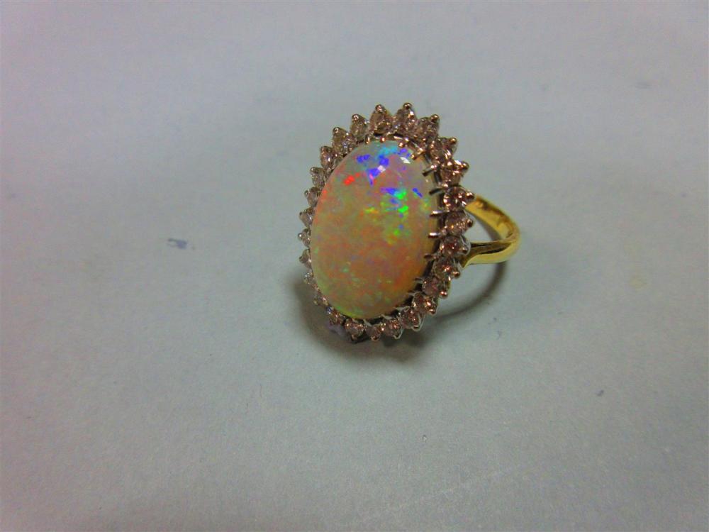 An opal and diamond cluster ring, the 17mm long oval cabochon opal, displaying good predominantly - Image 2 of 4
