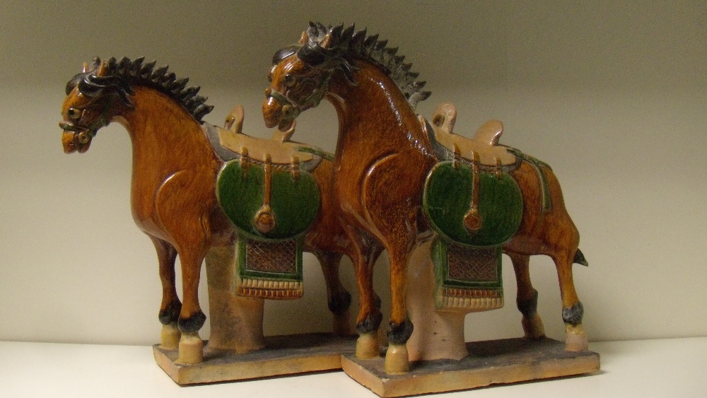 A pair of Chinese sangcai horses, modelled in the Tang taste, the green saddle cloths contrasting