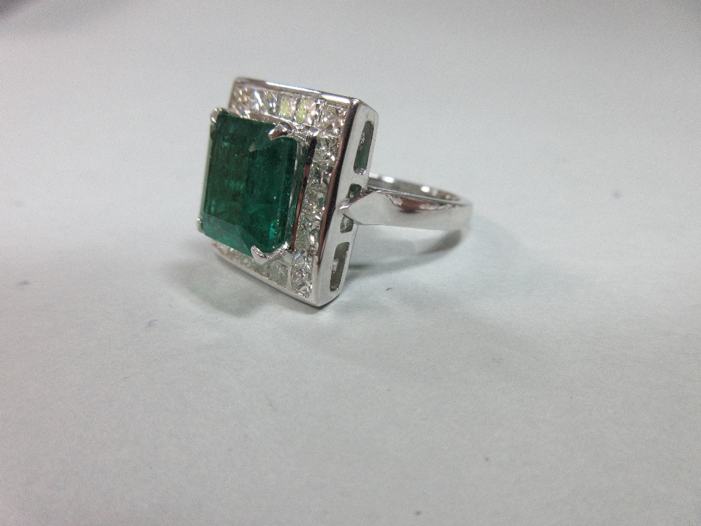 A large emerald and diamond cluster ring, the emerald cut emerald, estimated weight 4.78cts, above a - Image 3 of 8