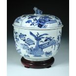 A Chinese Kangxi period blue and white bowl, cover and wood stand, each painted with four