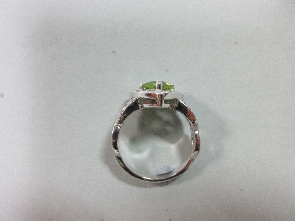 A contemporary peridot and diamond ring, the triangular cut peridot in a border of round brilliant - Image 6 of 7