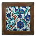 A 16th century Islamic Turkish Iznik tile in wooden frame painted with blue flowers, turquoise