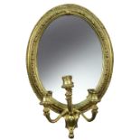 A pair of 19th century gilt gesso framed girandoles, with three branches, oval plate with beaded and