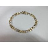 An 18ct bi-coloured gold and diamond set bracelet, the flattened curb link bracelet with every