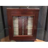 A 19th century mahogany microscope slide cabinet, the glazed door over twenty one drawers with