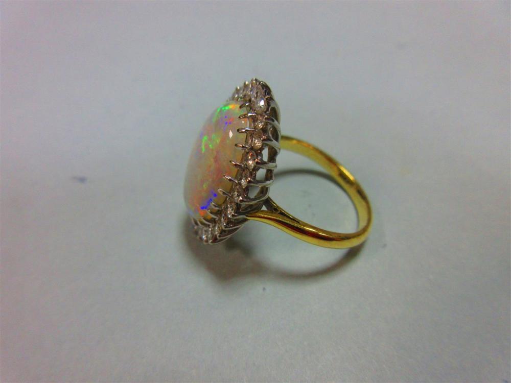 An opal and diamond cluster ring, the 17mm long oval cabochon opal, displaying good predominantly - Image 3 of 4