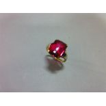 An Austrian single stone synthetic red spinel ring, the fancy cut rectangular pinky-red spinel, claw