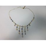 A pastel coloured sapphire fringe necklace in 18ct gold, set with a graduated line of round and oval