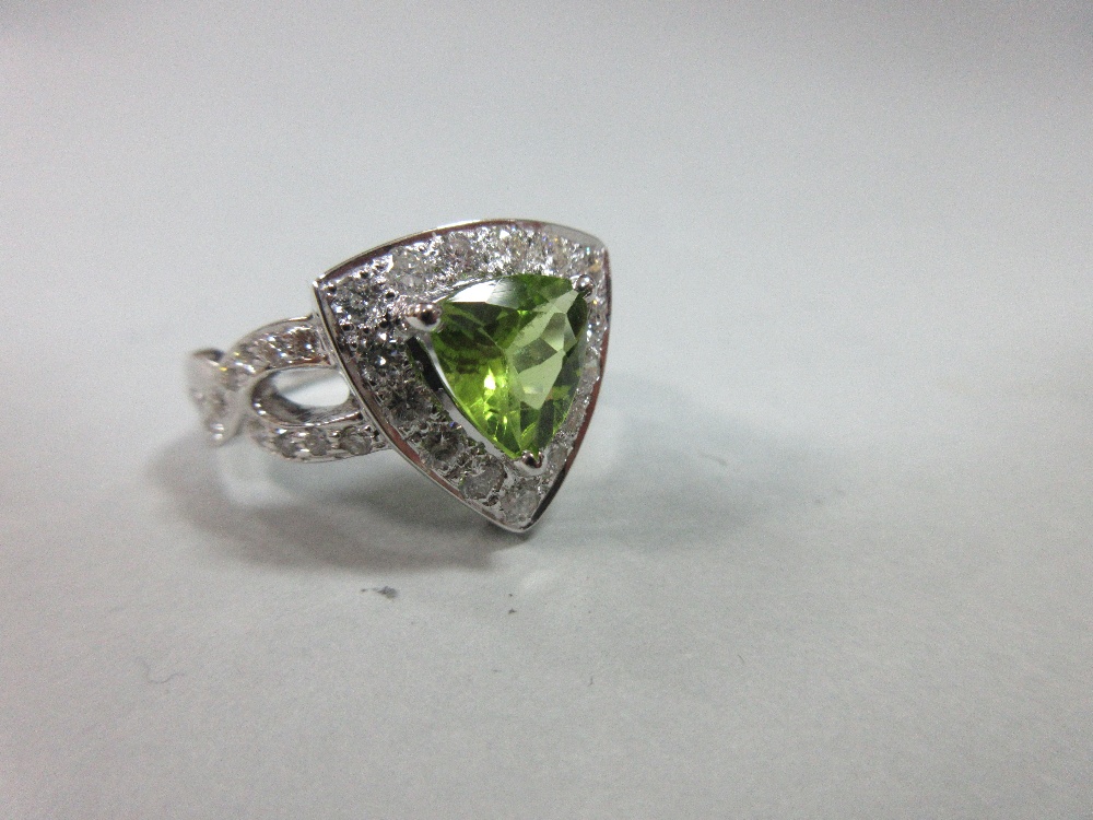 A contemporary peridot and diamond ring, the triangular cut peridot in a border of round brilliant - Image 7 of 7