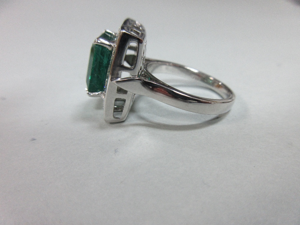 A large emerald and diamond cluster ring, the emerald cut emerald, estimated weight 4.78cts, above a - Image 4 of 8