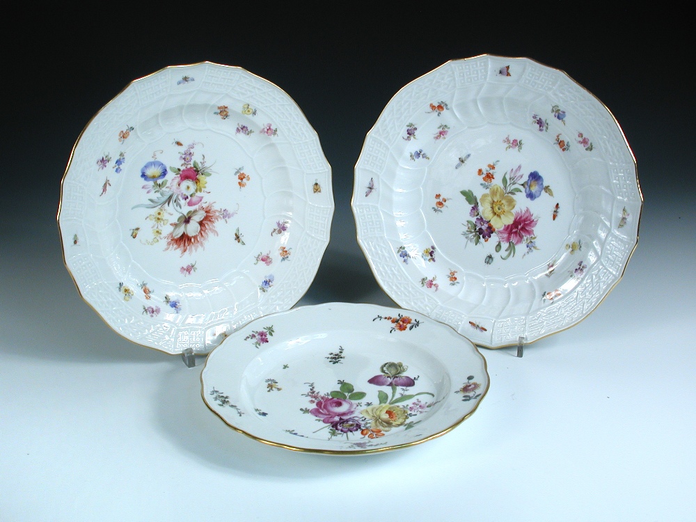 A pair and another Meissen floral plate, the former with basket moulded rims, crossed swords