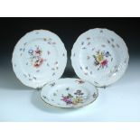 A pair and another Meissen floral plate, the former with basket moulded rims, crossed swords