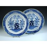 A pair of 18th century blue and white Delft chargers, each centrally painted with a rock and flowers