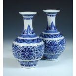 A pair of Chinese blue and white vases, each painted with leaf and lappet bands enclosing