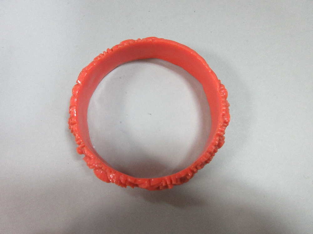 A graduated strand of coral beads and an early plastic carved 'coral' bangle, the necklace of - Image 7 of 7