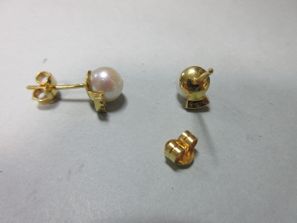 A pair of pearl and diamond earstuds, each post headed by a 7mm pearl above a short curved line - Image 2 of 2