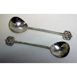 A pair of Arts and Crafts spoons, by A E Jones, Birmingham 1913, each with cast and hammered stem,