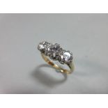 A three stone diamond and 18ct gold ring, the graduated round brilliant cut diamonds, total