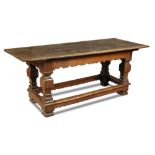 A 17th century oak Monks refectory table, the plank top on a shaped moulded frieze and square