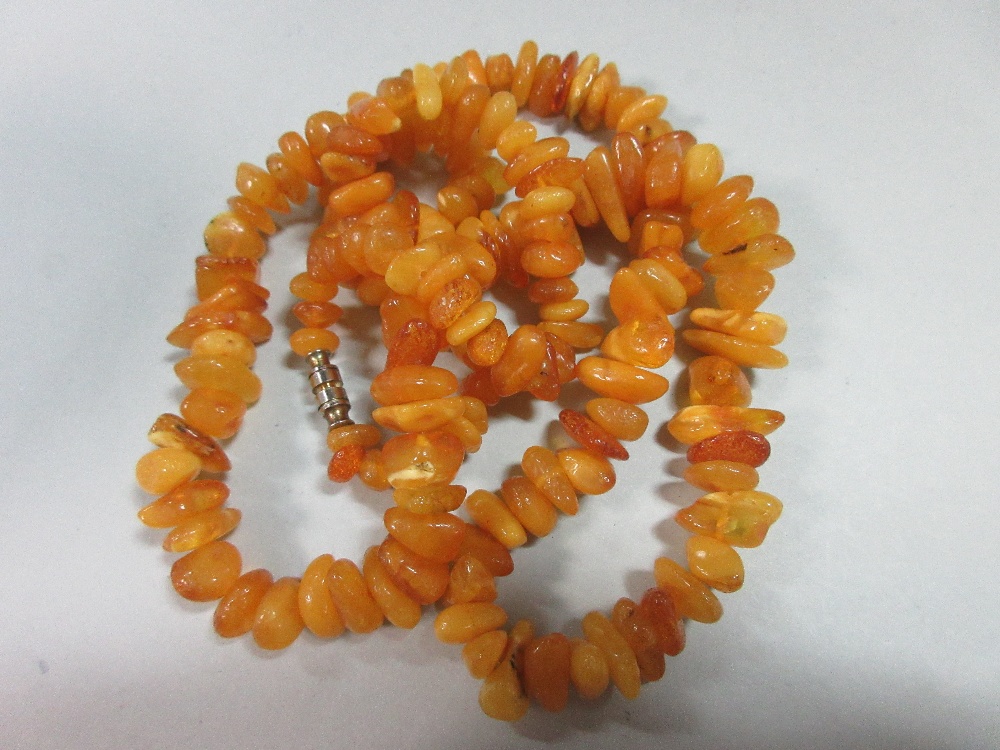 A butterscotch amber bead necklace, of graduated randomly shaped 'pebble' beads, gross weight 41.8g, - Image 3 of 4