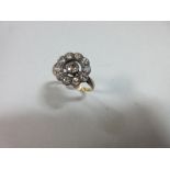 A diamond pierced cluster ring, with a central millegrain collet set round brilliant cut diamond