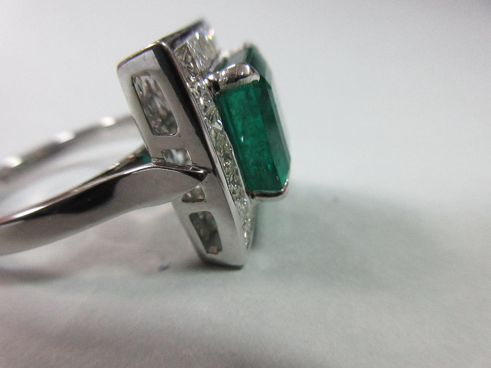 A large emerald and diamond cluster ring, the emerald cut emerald, estimated weight 4.78cts, above a - Image 7 of 8