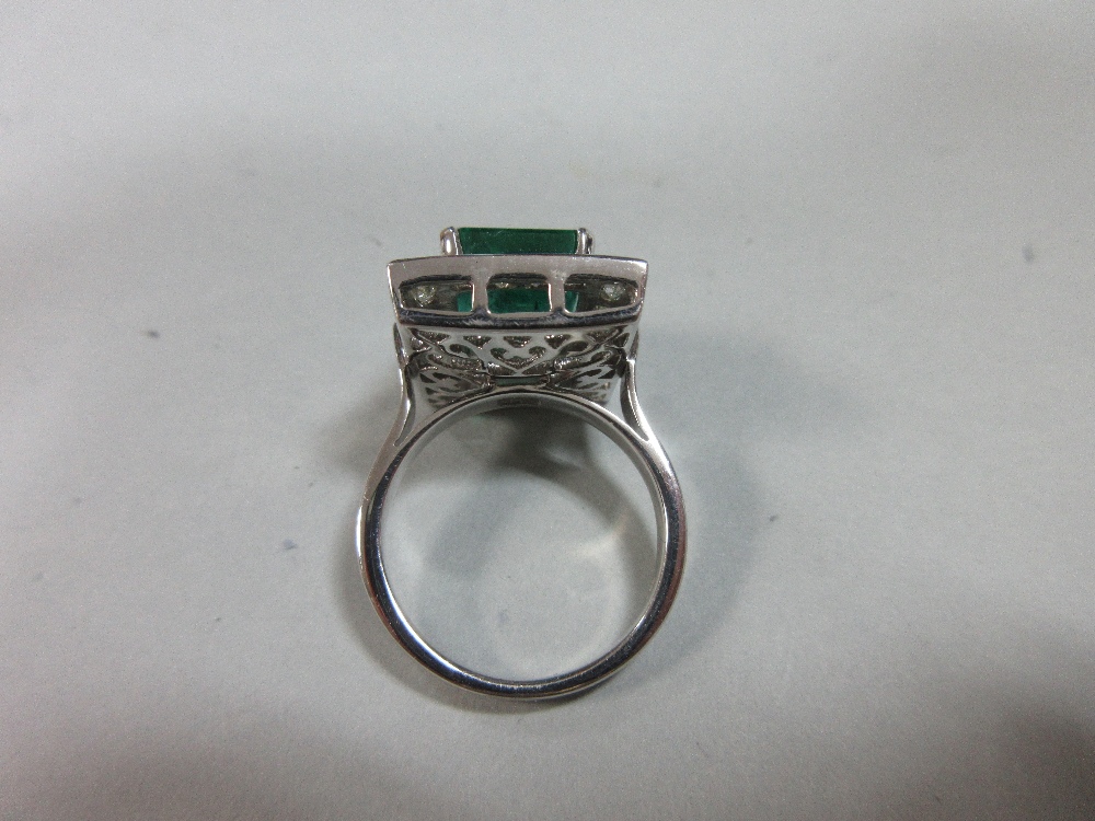 A large emerald and diamond cluster ring, the emerald cut emerald, estimated weight 4.78cts, above a - Image 6 of 8