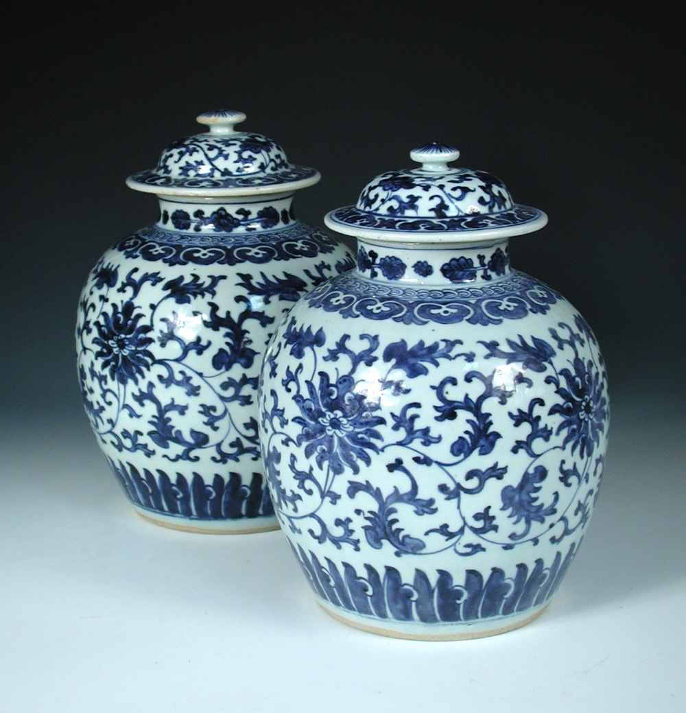 A pair of 19th century Chinese blue and white jars and covers, each painted with lotus scrolling